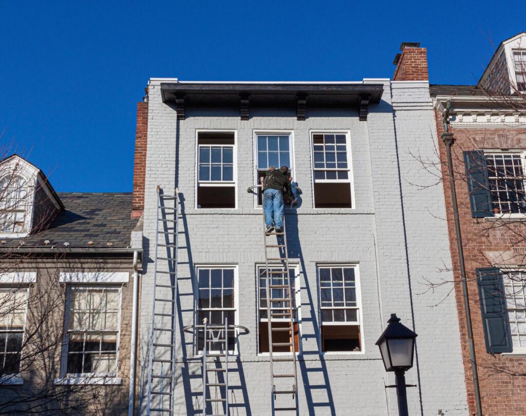 A worker doing premium house painting in Walled Lake, MI​ b